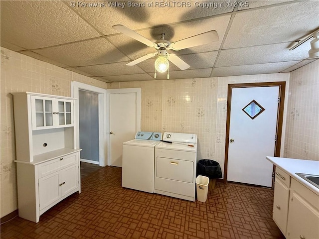 clothes washing area featuring ceiling fan, separate washer and dryer, and sink