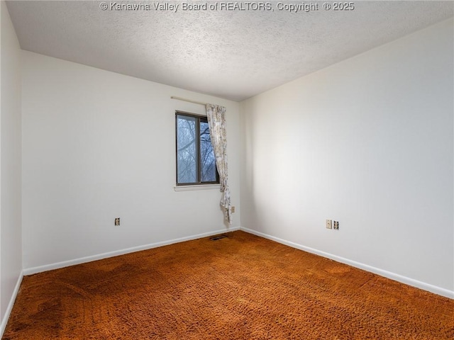 empty room with a textured ceiling and carpet flooring