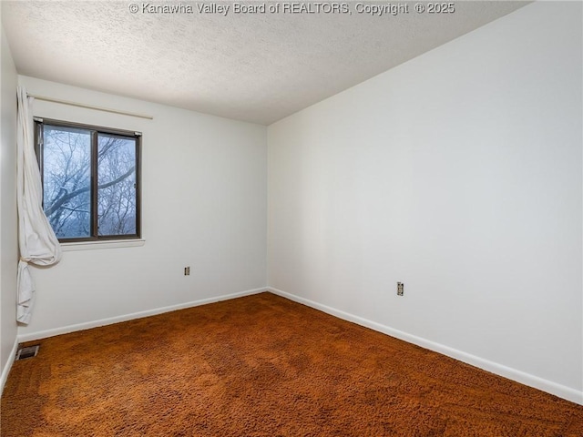 carpeted spare room with a textured ceiling