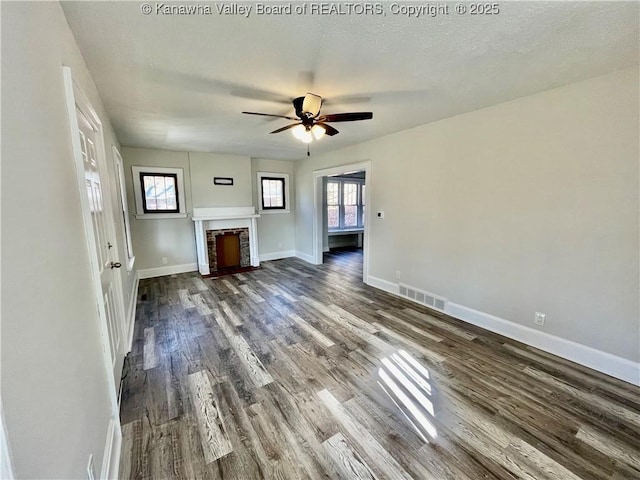 unfurnished living room with a textured ceiling, wood-type flooring, and ceiling fan