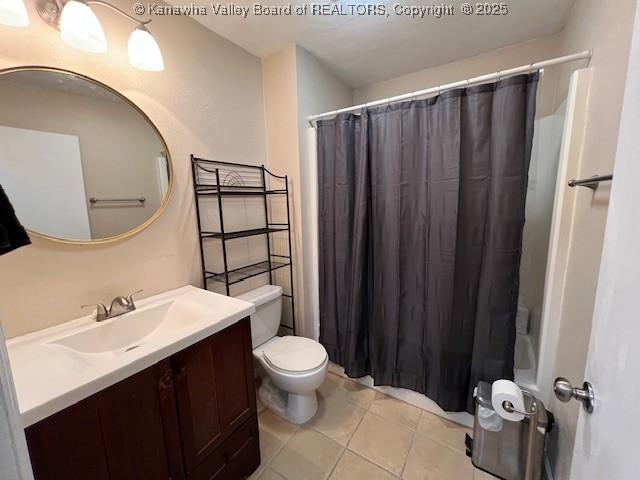 bathroom with vanity, tile patterned floors, toilet, and walk in shower