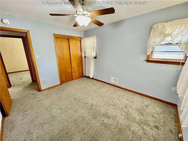 unfurnished bedroom with light colored carpet, ceiling fan, and a closet