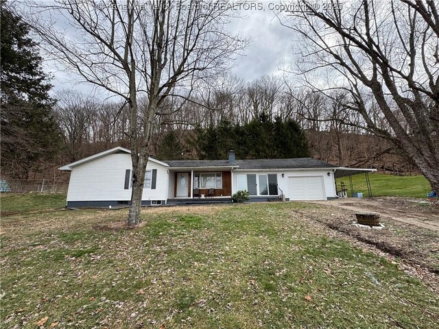 view of front of property featuring a garage, a front yard, and a carport