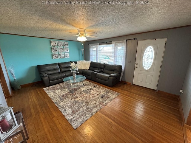 living room with ornamental molding, wood-type flooring, and a textured ceiling