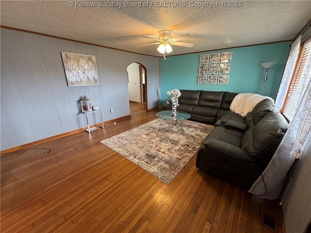 living room featuring hardwood / wood-style flooring, ornamental molding, and a textured ceiling