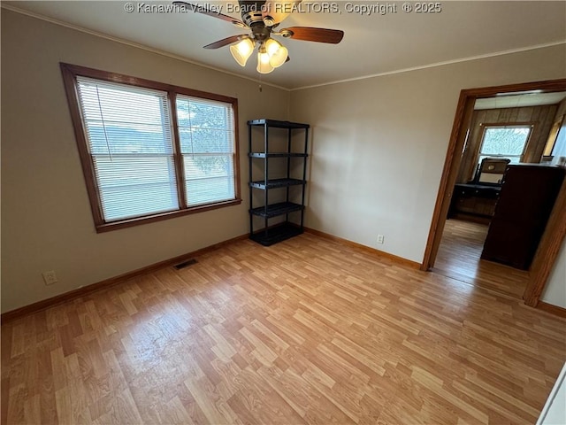 empty room with crown molding, ceiling fan, and light wood-type flooring