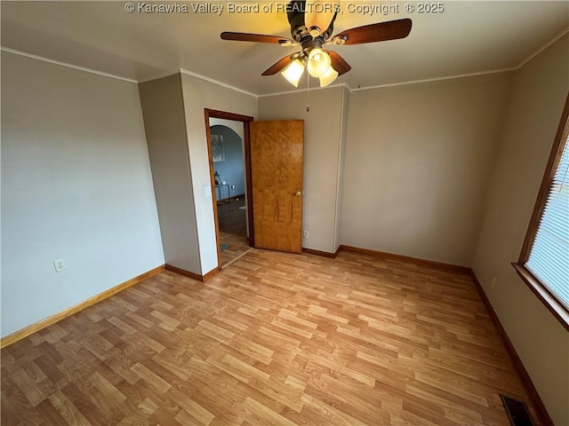 empty room with crown molding, ceiling fan, and light wood-type flooring