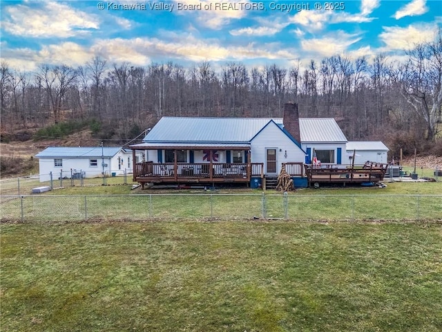 rear view of house with a wooden deck and a yard