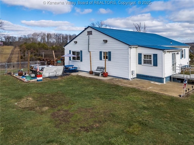 rear view of house featuring a patio and a lawn