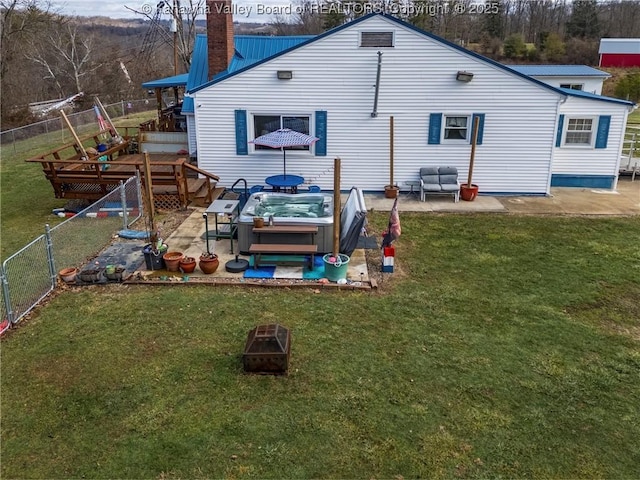 rear view of house featuring a hot tub, a patio, a yard, and a deck