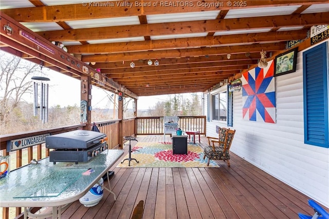 wooden deck with a grill and a fire pit