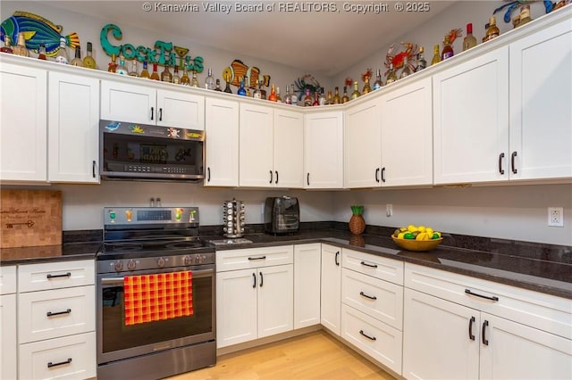 kitchen featuring dark stone counters, white cabinets, and appliances with stainless steel finishes