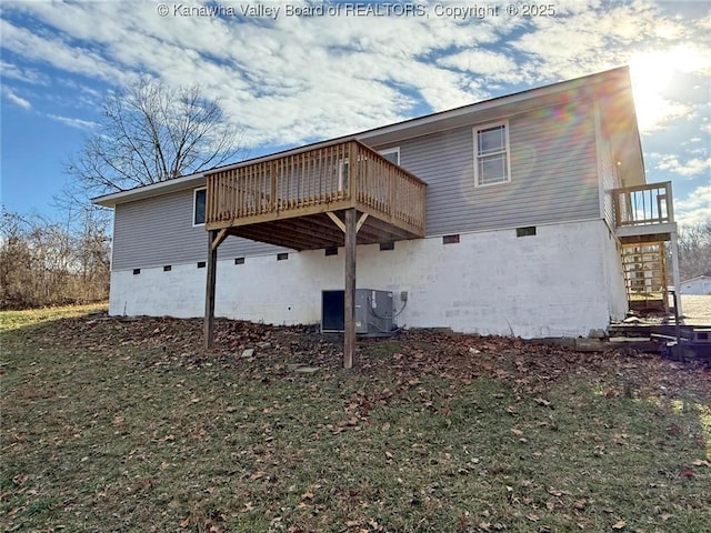 back of property with cooling unit, a deck, and a lawn