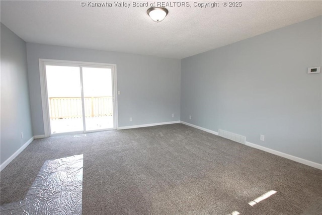 carpeted spare room featuring a textured ceiling