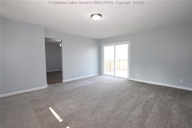 carpeted empty room featuring a textured ceiling