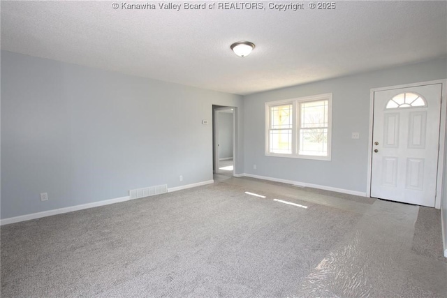 carpeted empty room featuring a textured ceiling