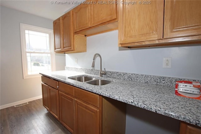 kitchen featuring sink, dark wood-type flooring, and light stone counters