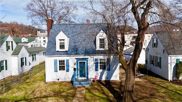 new england style home featuring a front yard