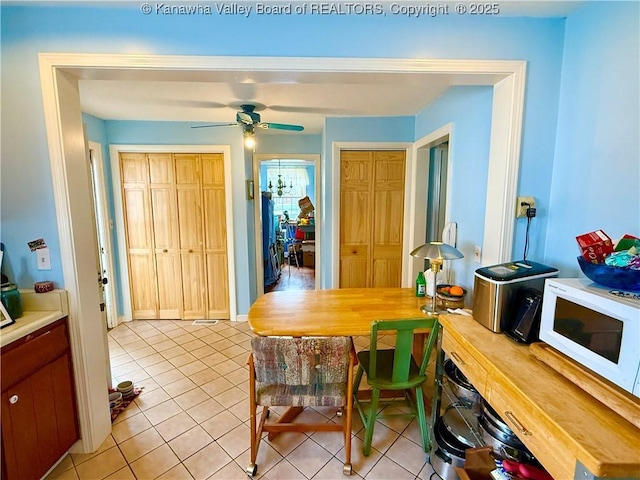 tiled dining area with ceiling fan