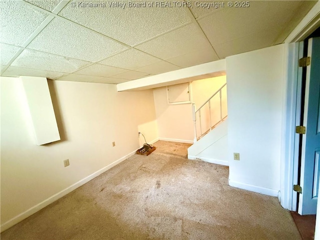 basement featuring a paneled ceiling and carpet