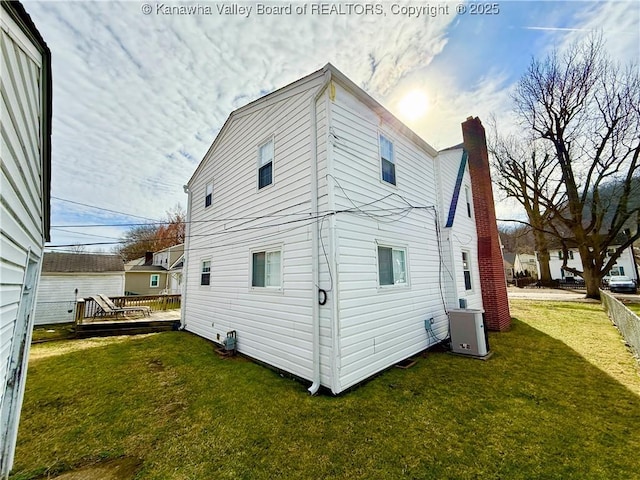 rear view of house with a wooden deck and a yard