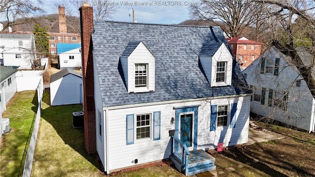 view of front of house with cooling unit and a front lawn