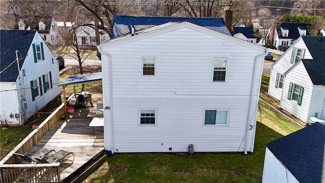 view of side of property featuring a deck and a lawn