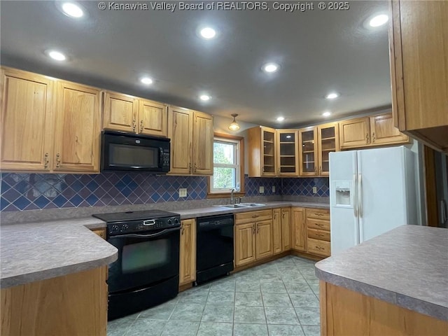 kitchen with tasteful backsplash, sink, light tile patterned floors, and black appliances