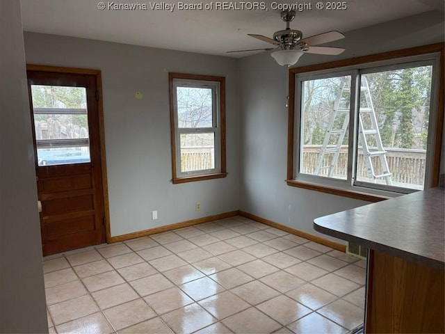 unfurnished dining area with light tile patterned flooring and ceiling fan