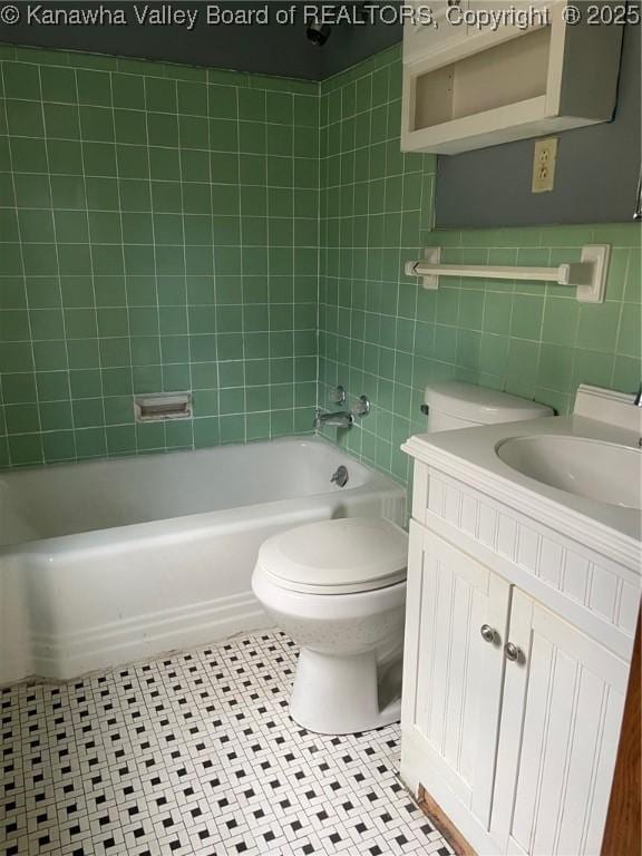 full bathroom featuring tile walls, tiled shower / bath combo, vanity, toilet, and tile patterned floors