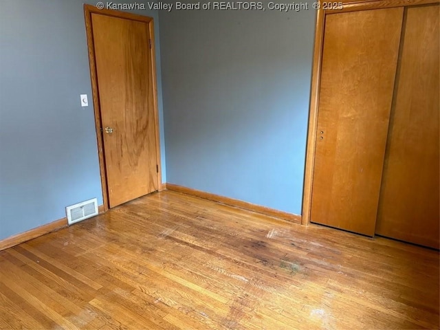 unfurnished bedroom featuring a closet and light hardwood / wood-style flooring