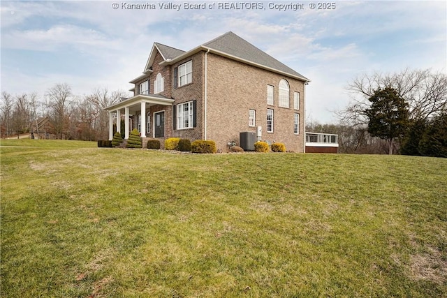 view of side of home with a porch, a yard, and central air condition unit