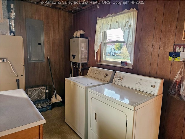 clothes washing area with independent washer and dryer, wooden walls, electric panel, and water heater