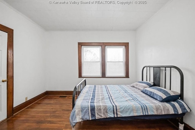 bedroom with crown molding and dark hardwood / wood-style floors