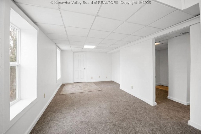 carpeted spare room with a drop ceiling