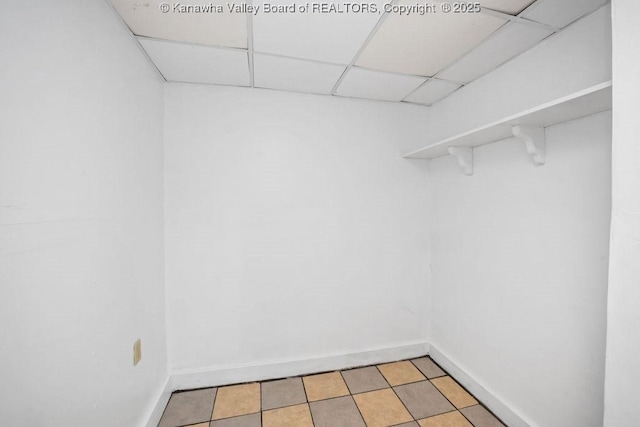 spacious closet with a drop ceiling and light tile patterned floors