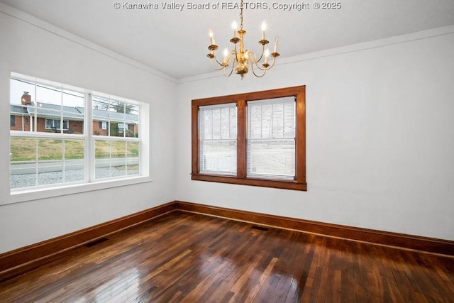 unfurnished room featuring dark wood-type flooring, ornamental molding, and a chandelier