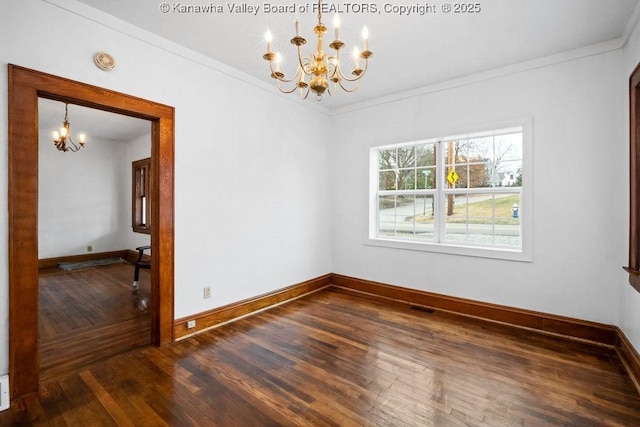 spare room featuring crown molding, dark hardwood / wood-style floors, and a notable chandelier