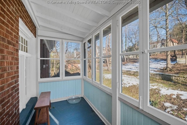 unfurnished sunroom with vaulted ceiling with beams