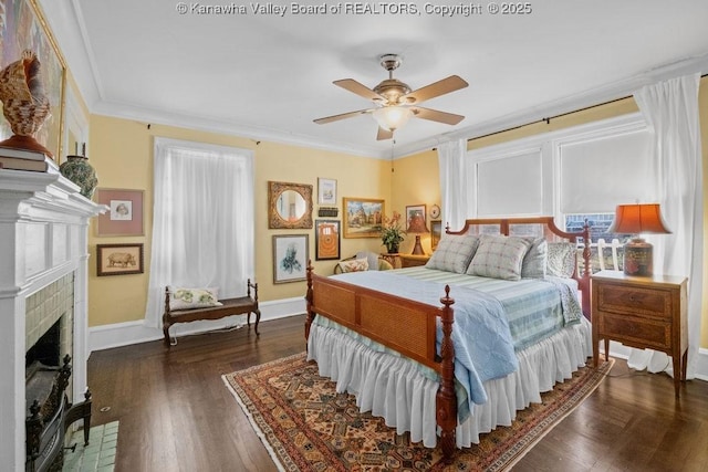 bedroom featuring crown molding, ceiling fan, dark hardwood / wood-style flooring, and a brick fireplace