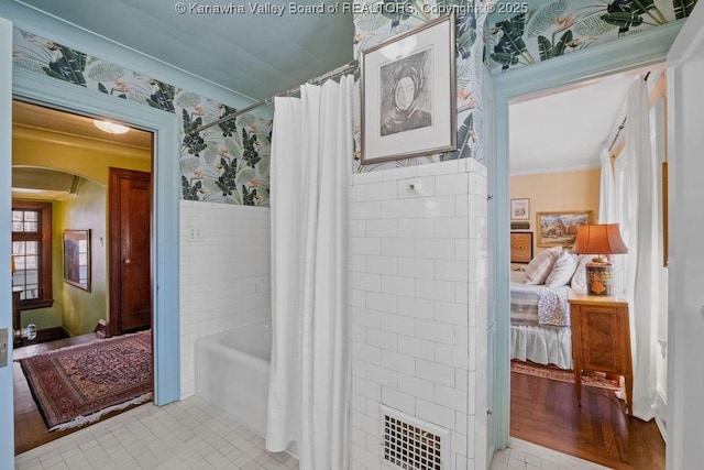 bathroom with ornamental molding, tile patterned flooring, shower / tub combo, and tile walls