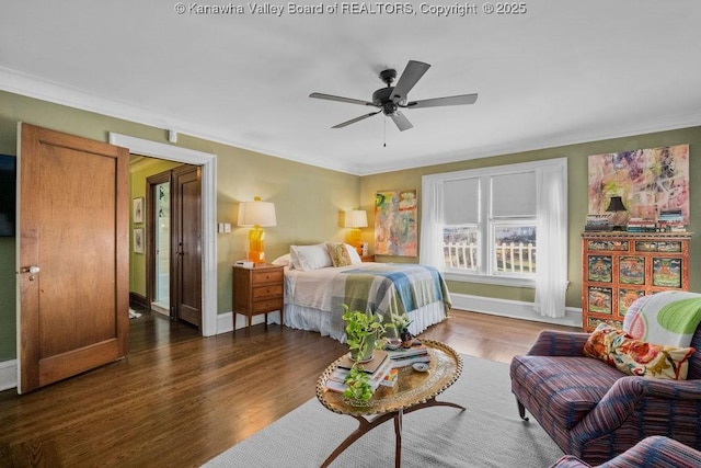 bedroom featuring dark wood-type flooring, ornamental molding, and ceiling fan