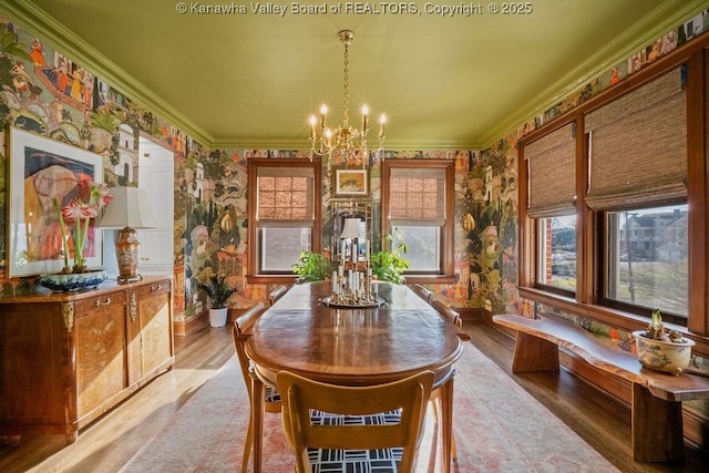 dining room featuring crown molding, an inviting chandelier, and hardwood / wood-style flooring