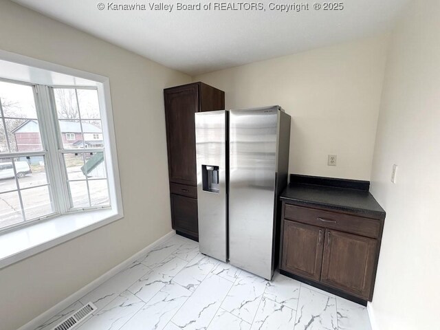 kitchen featuring dark brown cabinetry and stainless steel fridge