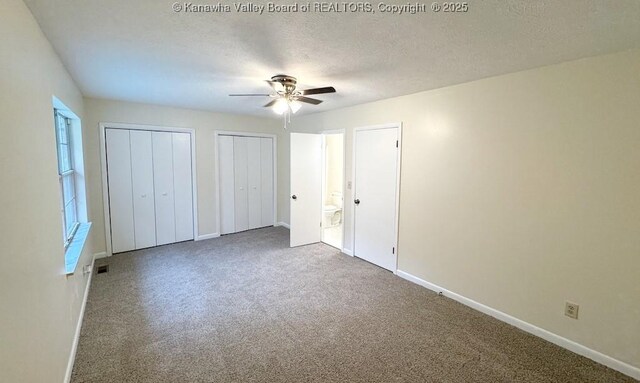 unfurnished bedroom featuring multiple closets, ceiling fan, carpet flooring, and a textured ceiling