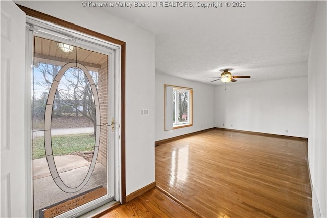 entrance foyer with ceiling fan, a healthy amount of sunlight, hardwood / wood-style floors, and a textured ceiling