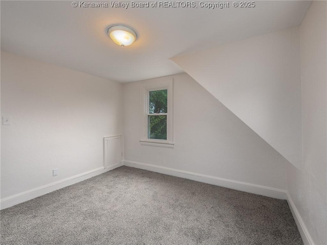 bonus room with vaulted ceiling and carpet