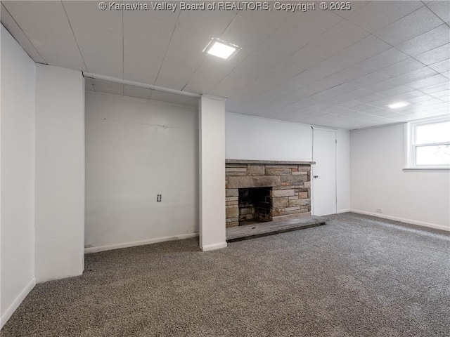 basement with a fireplace and carpet flooring