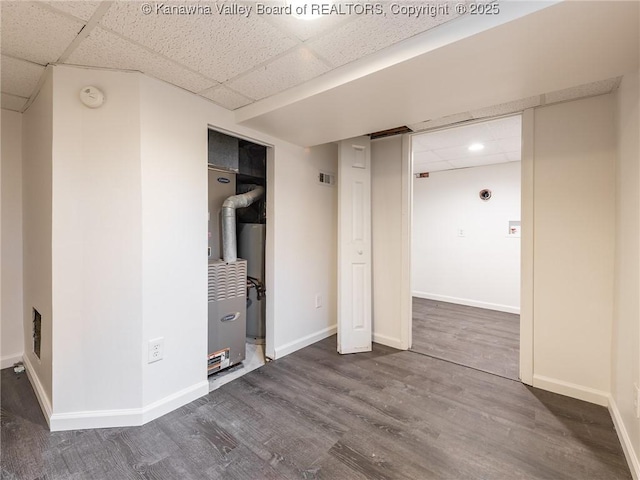 unfurnished bedroom featuring dark wood-type flooring and a paneled ceiling