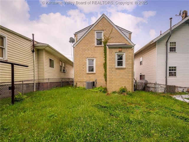 back of house with central AC unit and a lawn